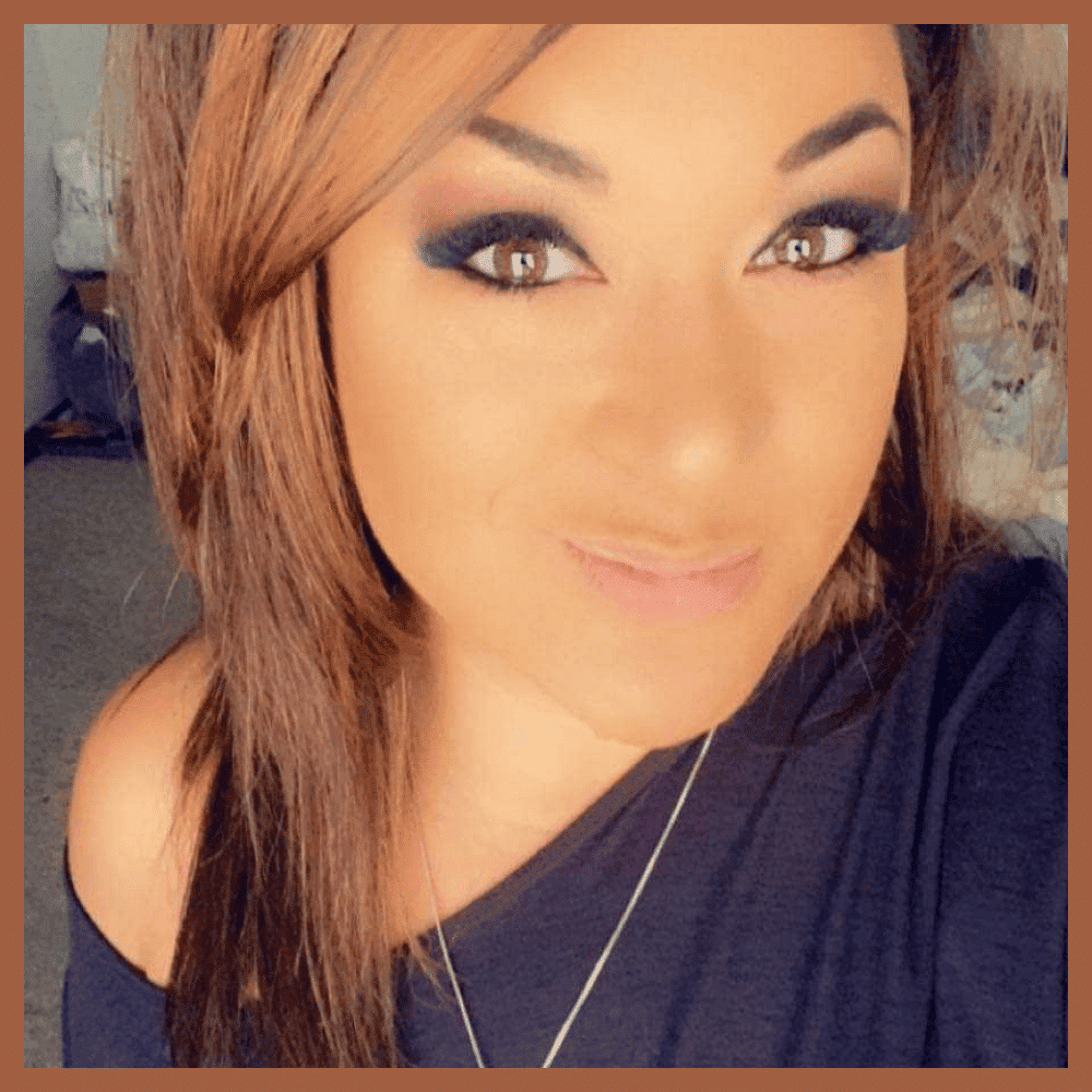 Woman with brown hair and makeup smiling at the camera.