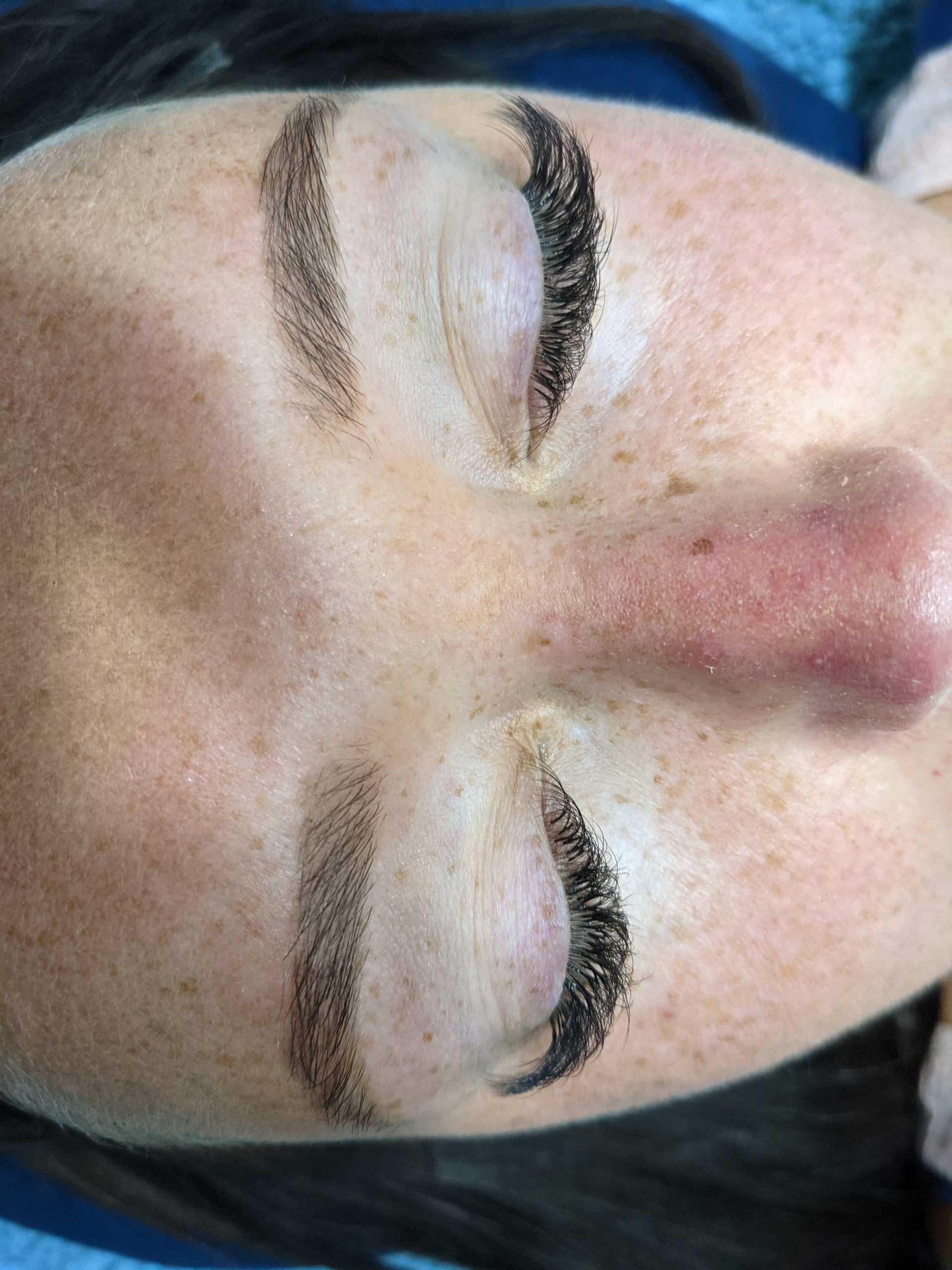 Closed eyes showing long lashes and groomed eyebrows on a serene face.