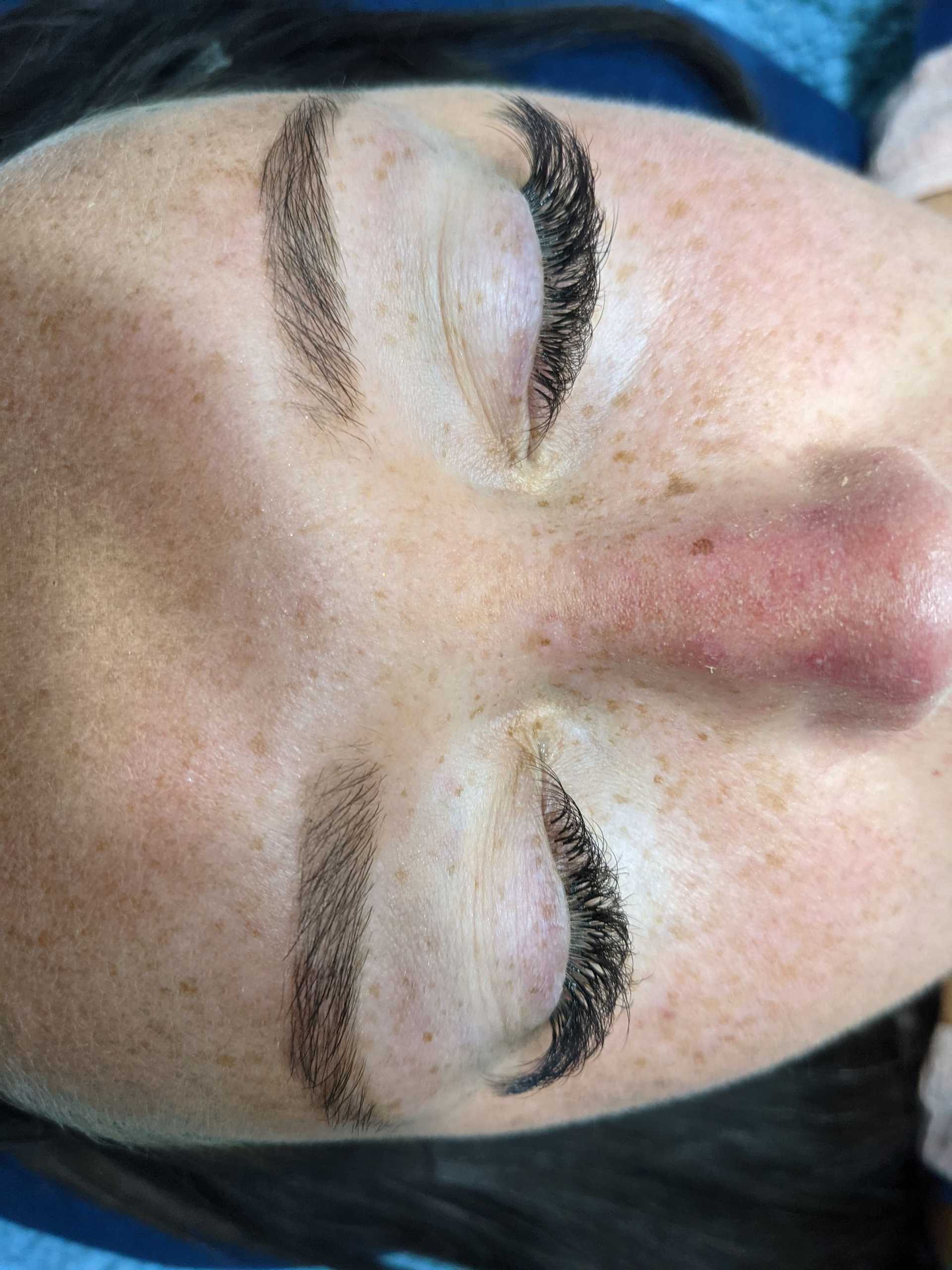 Closed eyes showing long lashes and groomed eyebrows on a serene face.